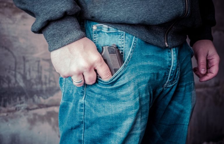 man pulling out a gun from his pocket