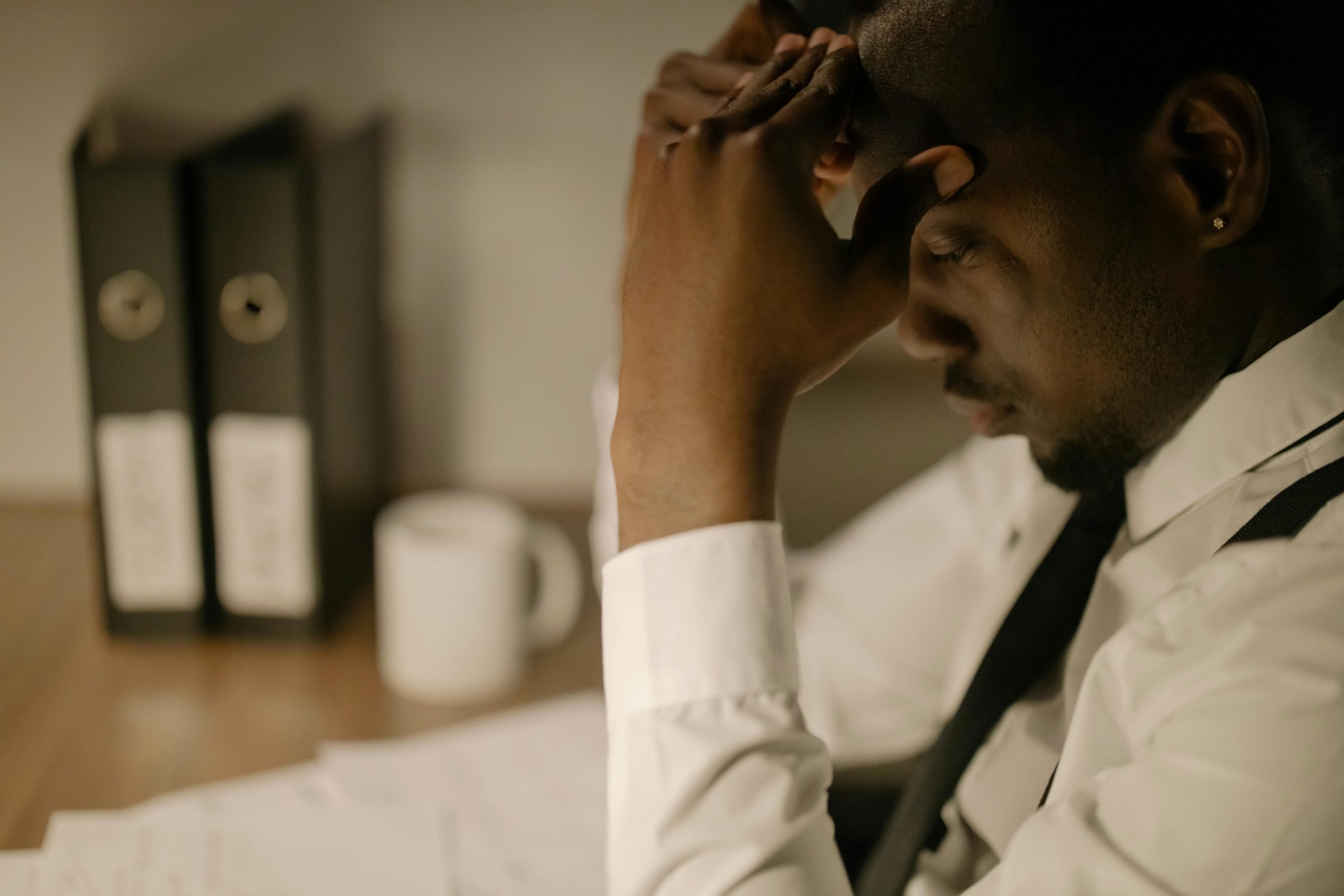 stressed employee holding his head, looking down