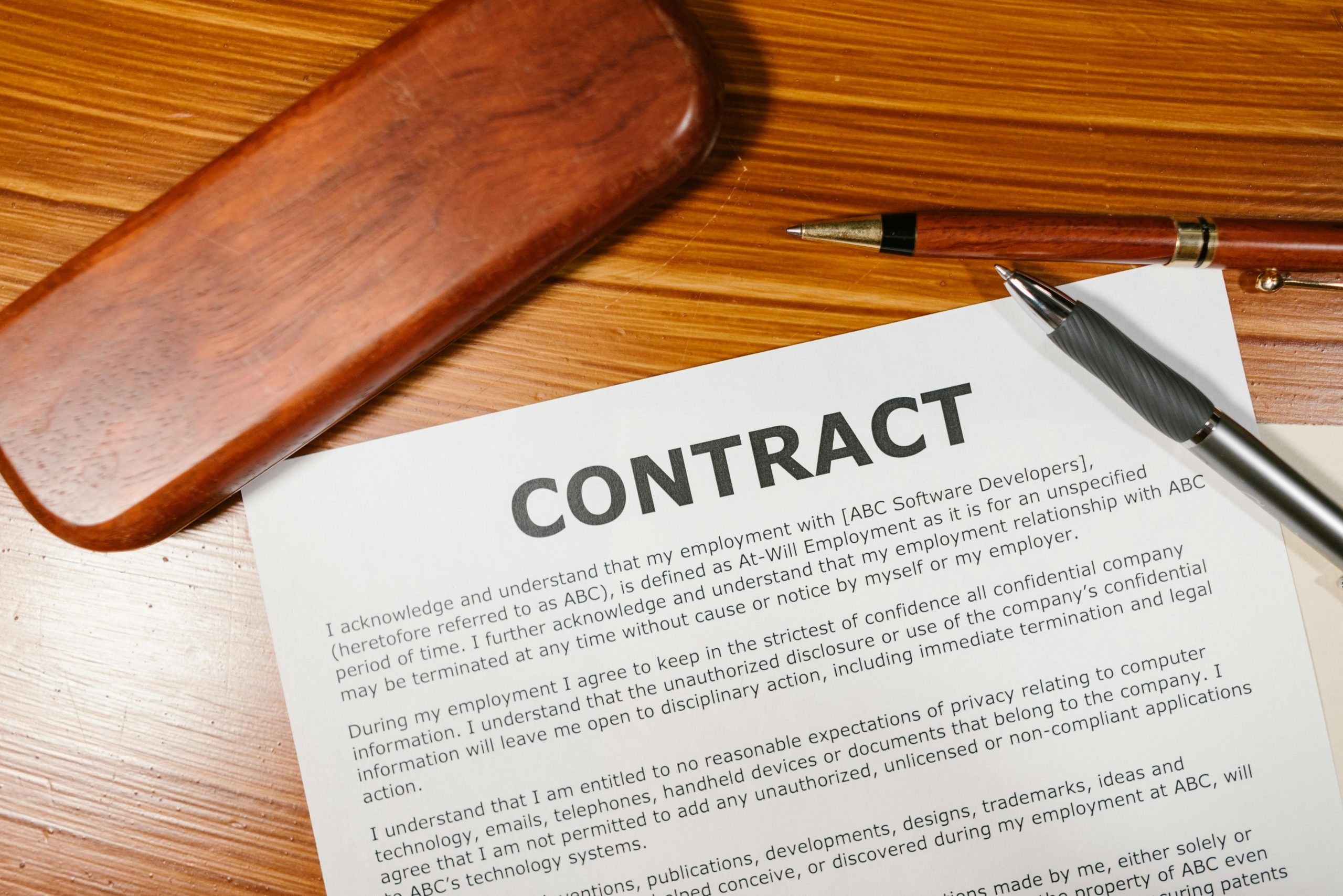 employment contract and pens on a wooden table